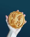 A Round Mooncake (Yuebing) With A Blessing Word. Hand Holding Moon Cake Pastry. Hands giving yuebing.Ã¦ÅËÃ©Â¤â¦